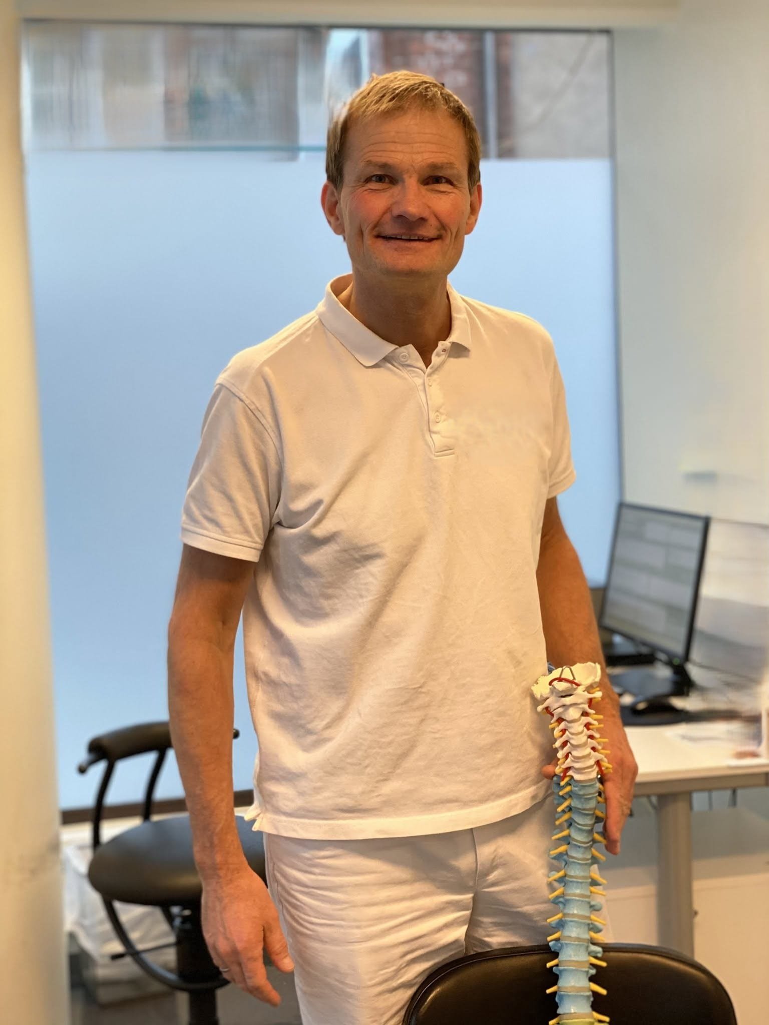 Gunnar Østby med en anatomisk ryggmodell i klinikken